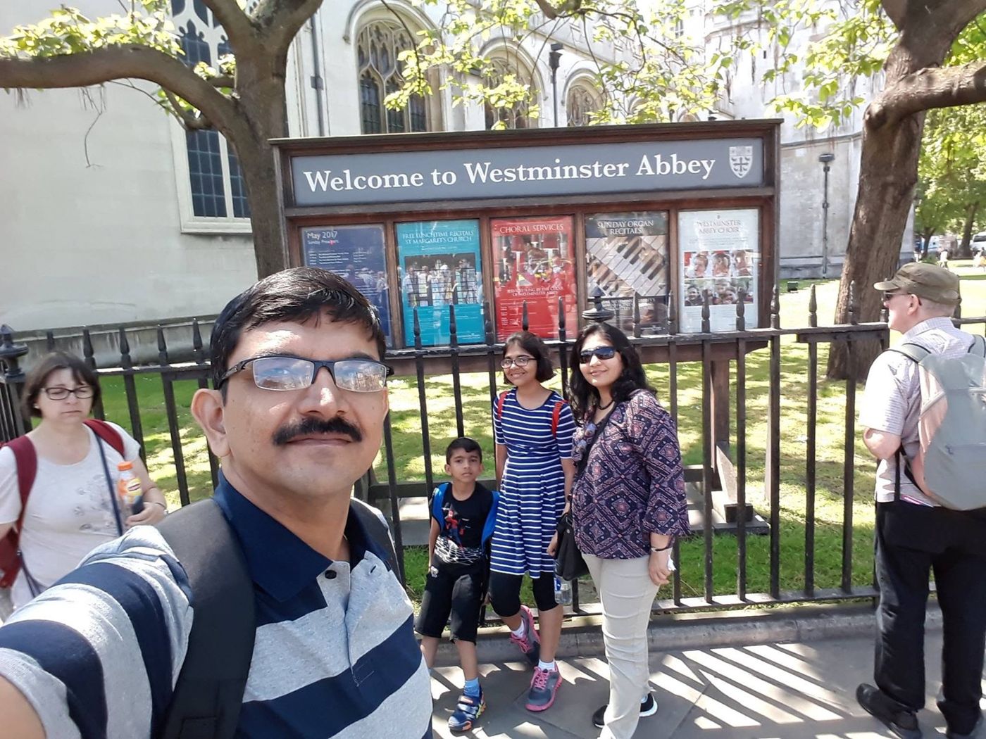 Family selfie in front of the Westminster Abbey sign