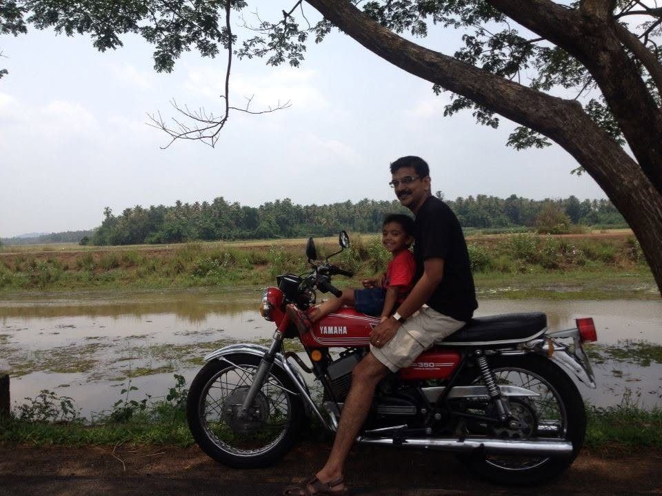 Bipin and Cyril on the red Yamaha RD 350 beside the wetlands