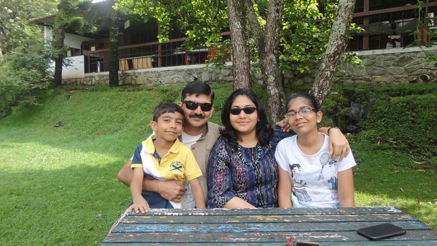 The family seated at a park bench in Kodaikanal