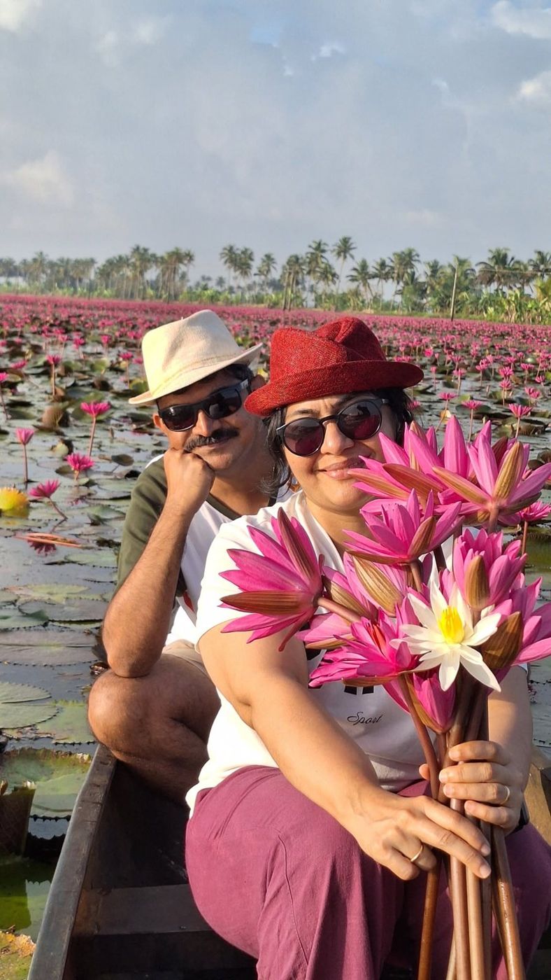Gathering pink water lilies from a boat